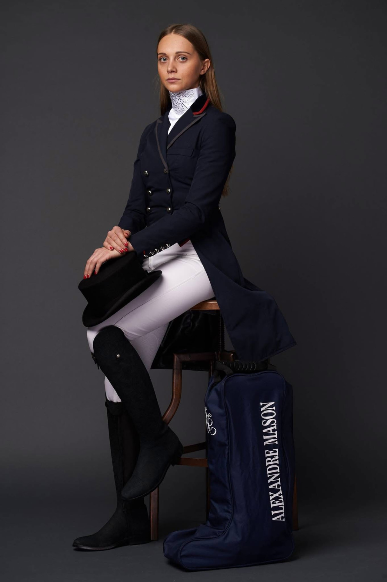 Dressage rider in a bespoke navy Alexandre Mason tailcoat with monogrammed boot bag